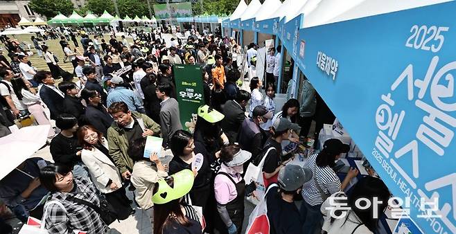 13일 서울 중구 서울광장에서 열린 2025 서울헬스쇼에 들른 시민들이 헬스 관련 부스 앞을 가득 메우며 길게 줄을 서 있다. 송은석 silverstone@donga.com·변영욱 기자