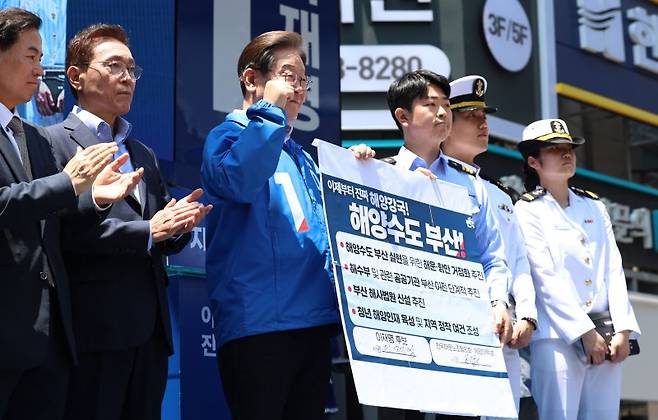 [부산=뉴시스] 권창회 기자 = 이재명 더불어민주당 대선 후보가 14일부산 부산진구 서면 젊음의 거리에서 열린 유세에서 권기흥 에이치라인해운해상직원노조 위원장과 해양수도 부산 협약서에 서명한 뒤 기념촬영을 하고 있다.2025.05.14. kch0523@newsis.com /사진=뉴시스