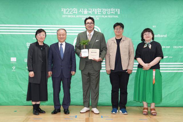 14일 서울 중구 환경재단 레이첼카슨홀에서 개최된 제22회 서울국제환경영화제 기자 간담회에서 공식 홍보대사로 위촉된 배우 조진웅(가운데)씨와 최열(왼쪽 두 번째) 조직위원장, 이미경(맨 왼쪽)·정재승(오른쪽 두 번째) 공동집행위원장, 장영자 프로그래머가 기념 사진을 촬영하고 있다. 배우 조진웅과 함께 작가 김은희도 홍보대사로 위촉됐다. 환경재단 제공