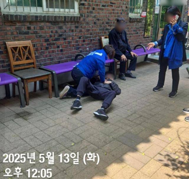 노연우(왼쪽) 서울 동대문구 의원이 심정지로 쓰러진 시민을 구하기 위해 응급처치를 취하고 있다. 해당 시간이 좌측 하단에 "2025년 5월 13일 오후 12시 5분"으로 표기돼 있다. 민병두 전 민주당 의원 페이스북 계정 캡처