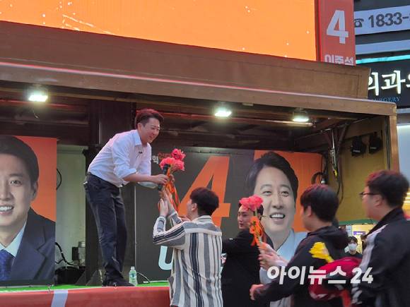 이준석 개혁신당 대선 후보가 14일 오후 부산 서면 '젊음의 거리'에서 유세를 진행하던 도중 지지자에게 꽃을 전달 받고 있다. [사진=김주훈 기자]