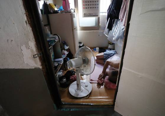 A resident cools down from the heat with an electric fan at a home in Jung District, central Seoul, on July 25, 2021. [NEWS1]
