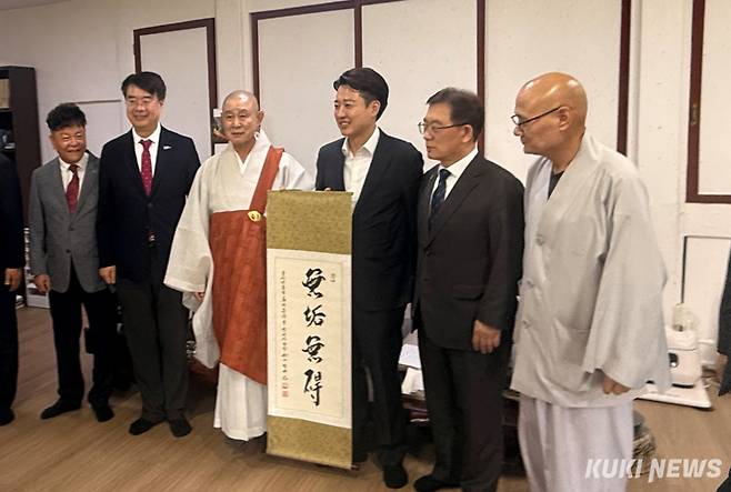 이준석 개혁신당 대선 후보가 14일 오후 범어사에서 ‘무구무애’(無垢無碍·허물이 없으면 장애물이 없다) 친필족자를 들고 정여스님(왼쪽) 등 종교계 지도자 및 관계자와 기념촬영하고 있다. 송금종 기자&nbsp;