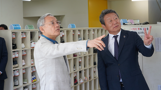 유인촌 문화체육관광부 장관(왼쪽)과 최윤 OK금융그룹 회장이 OKIS 학교 시설을 살펴보고 있다. [사진=OK금융그룹]