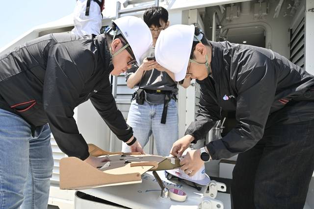 지난 12일 울산 일산항 인근 해상에서 진행된 해군 주관 ‘전ㆍ평시 상용 무인체계 작전 운용 가능성 검증훈련’에 참가한 드론 운용 민간 요원들이 선박해양플랜트연구소 해양누리호 갑판에서 골판지 드론 이륙을 위한 준비를 하고 있다.. 해군 제공