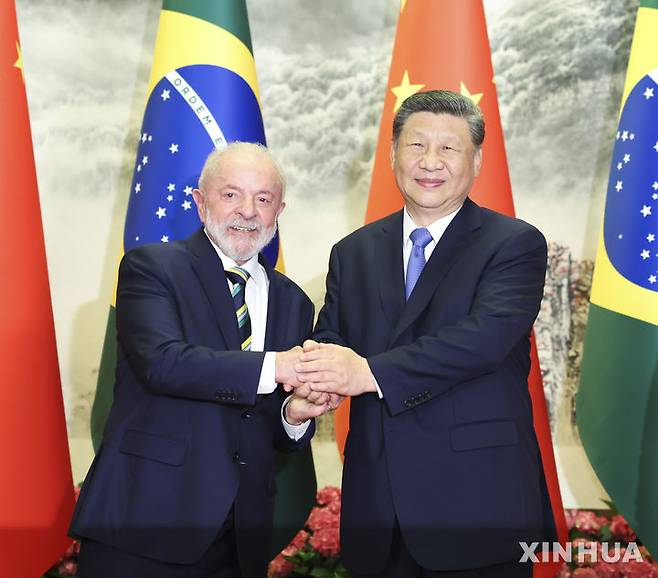 [베이징=신화/뉴시스] 시진핑 중국 국가주석(오른쪽)과 루이스 이나시우 룰라 다시우바 브라질 대통령이 13일 베이징 인민대회당에서 정상회담에 앞서 악수하고 있다. 중국은 미국과 관세 전쟁에서 승리한 것으로 자평하면서 자국의 영향력을 전 세계에 확대하는데 집중하고 있다.  2025.05.14.