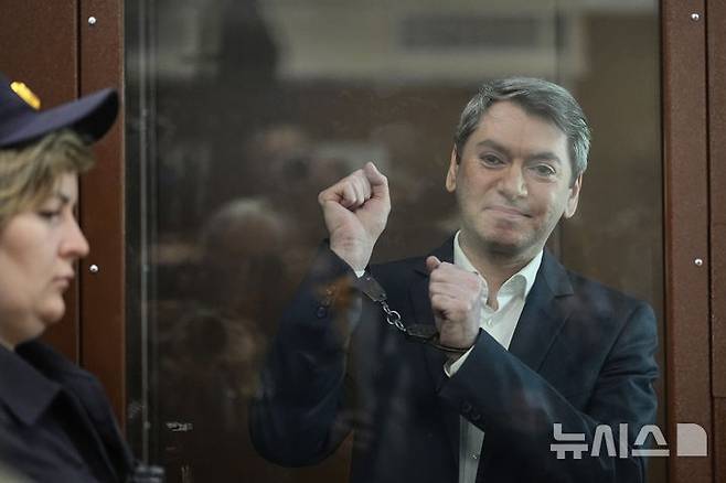 [모스크바=AP/뉴시스]러시아 모스크바 바스마니 지방법원에서 14일 재판이 열리기 전 러시아의 대표적인 독립 선거감시단체 골로스의 공동의장 그리고리 멜코냔츠가 법정에 온 기자들을 바라보고 있다. 법원은 이날 멜코냔츠에게 "바람직하지 못한 조직의 활동을 이끈" 혐의로 유죄를 선고, 징역 5년형을 선고했다. 2025.05.14.
