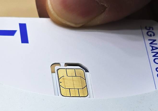 지난 12일 서울 시내 한 SK텔레콤 대리점에서 직원들이 유심 재설정을 시연하는 모습. 연합뉴스