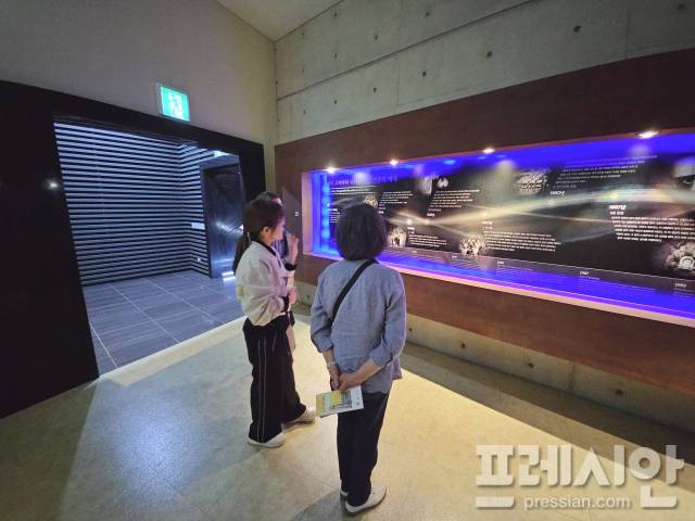 ▲13일 광주 북구 운정동 국립5·18민주묘지 추모관에서 일본 요코하마에서 온 사토 부부가 5·18의 시대적 배경에 대한 해설사의 설명을 듣고 있다.2025.05.013ⓒ프레시안(김보현)