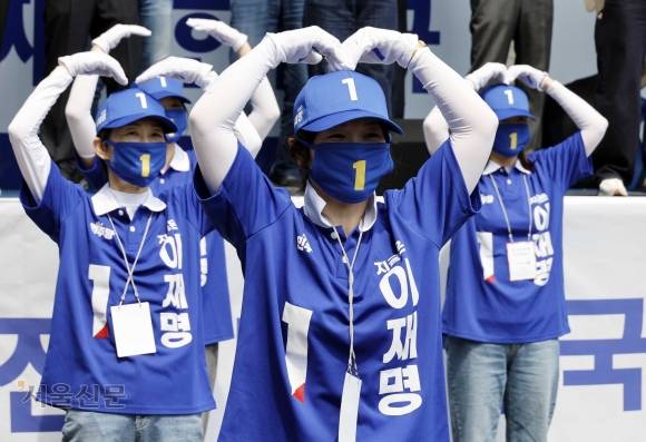 대선 공식 선거운동 이틀째인 13일 더불어민주당 선거사무원들이 경북 구미역 광장에서 이재명 후보의 이름이 적힌 선거운동복을 입고 하트를 그리는 율동을 하고 있다.  구미 홍윤기 기자