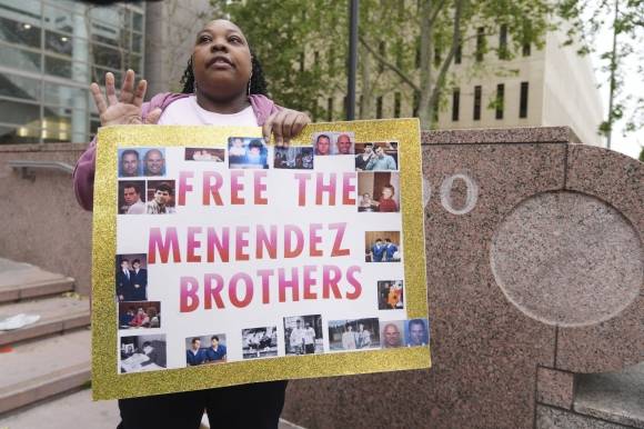메넨데스 형제의 지지자가 법정 밖에서 팻말을 들고 있는 모습. 2025.4.18 AP 연합뉴스