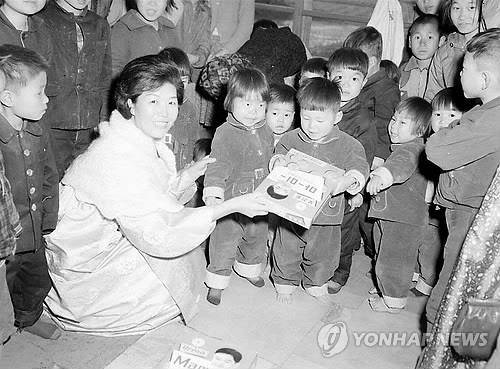 보육원 찾아 선물 건네는 육영수 여사 (서울=연합뉴스) 1965년 박정희 대통령 부인 육영수 여사가 대구시 소재 한 보육원을 방문해 원생들과 즐거운 시간을 보내던 모습.