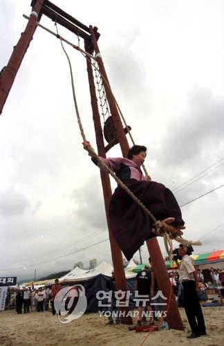 단옷날 그네뛰기 중요무형문화재 제13호인 강릉단오제가 열린 18일 남대천 단오장터에 마련된 그네에서 단오날을 맞아 구경왔던 아낙이 그네를 뛰고 있다.(본사자료)1999.6.18(강릉=연합뉴스)