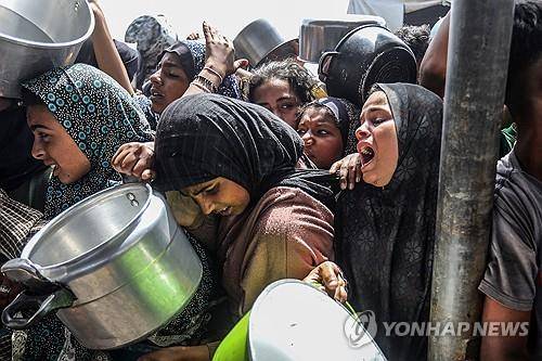 음식 얻으려는 가자지구 주민들 (가자지구 칸유니스 UPI=연합뉴스) 2025년 5월 12일 가자지구 칸유니스에서 팔레스타인인 주민들이 구호단체들이 나눠주는 음식을 받으려고 하고 있다. (Photo by Anas Deeb/UPI) 2025.5.14.