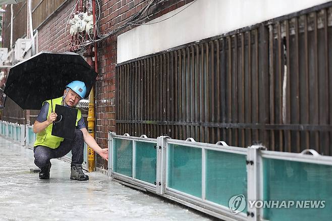 서울시, 장마철 침수 우려 반지하 긴급 점검 (서울=연합뉴스) 신현우 기자 = 8일 서울 관악구 한 주택가에서 서울시건축사회 소속 건축사들이 침수 우려 반지하 가구를 점검하며 취재진에게 관련 내용을 설명하고 있다.
    서울시는 침수 방지시설 설치가 필요한 반지하 2만8천여 가구 가운데 최우선 관리 대상인 1만5천여 가구에 대해 이날부터 10일간 긴급 점검을 벌인다고 밝힌 바 있다. 2024.7.8 nowwego@yna.co.kr