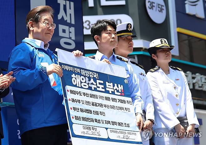 이재명 후보, 해양수도 부산 협약서 서명식 (부산=연합뉴스) 황광모 기자 = 더불어민주당 이재명 대선 후보가 14일 부산 부산진구 서면 젊음의 거리에서 열린 유세에서 권기흥 에이치라인해운해상직원노조 위원장과 해양수도 부산 협약서에 서명한 후 기념 촬영하고 있다. 2025.5.14 [공동취재] hkmpooh@yna.co.kr