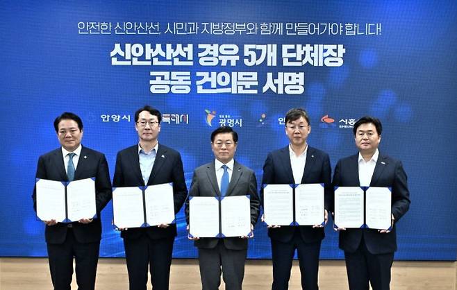15일 오전 광명시청에서 (왼쪽부터)최대호 안양시장, 정명근 화성시장, 박승원 광명시장, 이민근 안산시장, 임병택 시흥시장이 신안산선 경유 5개 단체장 공동 건의문에 서명하고 기념촬영을 하고 있다. 사진=광명시청
