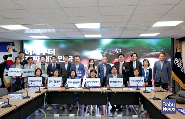 15일 오전 11시 민주당 중앙당사 4층 대회의실에서 열린 인구미래위원회 출범회의에서 참석자들이 한자리에 모여 '행복한 출생 함께하는 돌봄', '진짜 대한민국' 슬로건이 담긴 피켓을 들고 기념촬영을 하고 있다. ⓒ베이비뉴스 이효상 기자