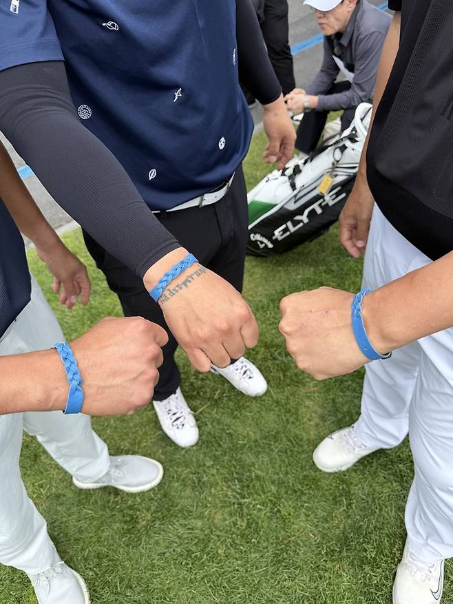 지적장애인 작가들과 소셜벤처 ‘같이 걸을까?’가 협업해 출시한 ‘엮다팔찌’를 착용한 이대호 김태균 박용택이 손을 맞대고 있다. 사진 | SKT