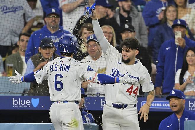 김혜성이 5회 동점 솔로홈런을 치고 들어오자 앤디 파헤스가 해바라기씨를 뿌려주고 있다. AP연합뉴스