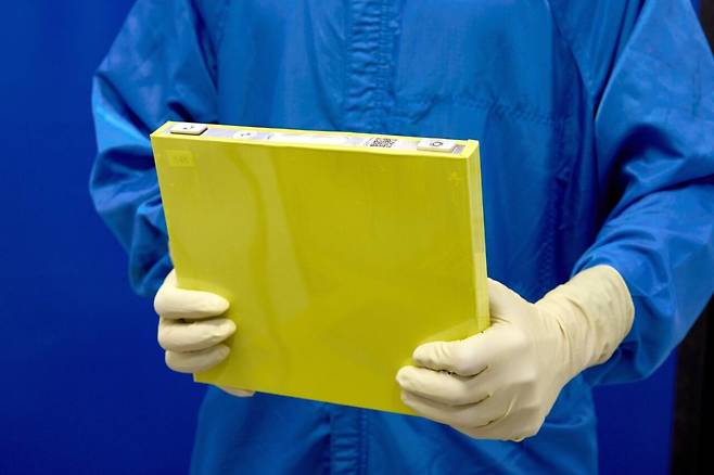 미국 GM(제너럴모터스) 직원이 실물 크기의 LMR(리튬망간리치) 배터리 시제품을 들고 있는 모습. / GM