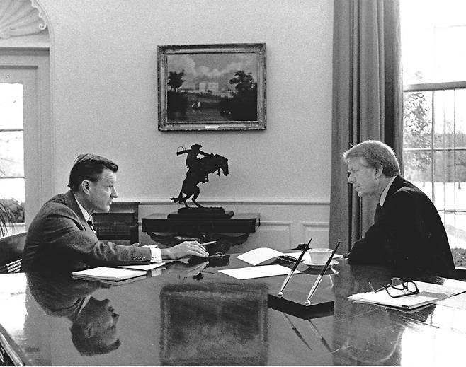 1977년 1월 21일 지미 카터 대통령 취임 첫 날 워싱턴 DC 백악관 집무실에서 지미 카터 미국 대통령(오른쪽)에게 보고하는 브레진스키 국가안보보좌관./백악관 via CNP