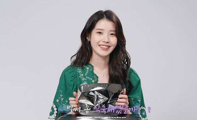 14일 가수 겸 배우 아이유가 유튜브에서 받은 다이아 버튼을 공개하고 있다. /유튜브 채널 '이지금(IU Official)' 화면 캡처