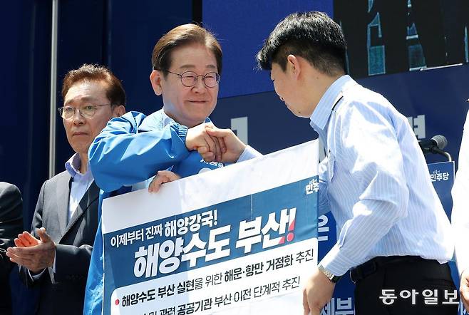 더불어민주당 이재명 대선 후보(왼쪽)가 14일 부산 부산진구 서면 젊음의 거리에서 열린 유세에서 해양수도 부산 협약서에 서명한 뒤 권기흥 에이치라인해운해상직원노조 위원장과 악수하고 있다. 이 후보는 이날 해양수산부와 국내 최대 해운회사 HMM의 부산 이전 등을 약속했다. 부산=이훈구 기자 ufo@donga.com