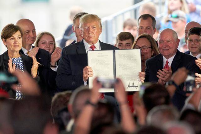 도널드 트럼프 미 대통령이 지난 2019년 11월 카운실 블러프스에 있는 사우스웨스트 아이오와 재생에너지 에탄올 생산 시설을 방문해, GMO 농산물 승인 관련 절차 완화와 수출 촉진을 위한 행정명령에 서명한 후 이를 들어보이고 있다. AP연합뉴스