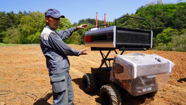 농민 장동관씨가 대동의 운반로봇 RT100 사용법을 설명하고 있다. 장씨는 RT100 첫 구매자다. 대동 제공