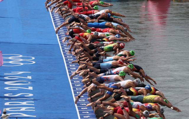 2024 파리올림픽 트라이애슬론 경기가 열린 지난해 7월 31일 프랑스 파리 알렉산드르 3세 다리에서 출전 선수들이 센강으로 뛰어들고 있다. 트라이애슬론 남자 경기는 당초 같은 달 30일에 진행될 계획이었으나 센강 대장균 검출 수치 초과 등 수질 문제가 발생해 하루 연기됐었다. 파리=서재훈 기자