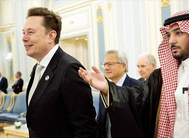 < 사우디 간 美 빅테크 수장들 > 도널드 트럼프 미국 대통령의 중동 순방에 동행한 일론 머스크 테슬라 최고경영자(CEO·왼쪽 첫 번째)와 젠슨 황 엔비디아 CEO(두 번째)가 13일(현지시간) 사우디아라비아 리야드에서 열린 포럼에서 사우디 측의 안내를 받으며 이동하고 있다. /AFP연합뉴스