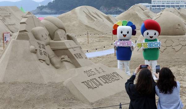 모래작품으로 대선투표 독려- 제21대 대통령선거를 앞둔 15일 부산 해운대해수욕장 모래축제 현장에서 부산시선거관리위원회가 투표참여를 독려하는 모래작품을 배경으로 홍보 캠페인을 벌이고 있다.  전민철 기자 jmc@kookje.co.kr