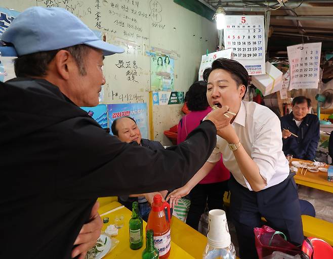 이준석 개혁신당 대선후보가 지난 14일 부산 자갈치시장을 방문해 지지를 호소하던 중 시민이 준 음식을 먹고 있다.  [연합]