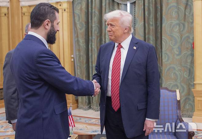 [리야드(사우디아라비아)=AP/뉴시스] 도널드 트럼프 미 대통령(오른쪽)이 14일 사우디아라비아 리야드에서 아흐마드 알-사라 시리아 임시 대통령과 악수하고 있다. 2025.05.15.