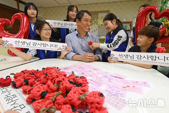 [수원=뉴시스] 김종택 기자 = 스승의 날을 하루 앞둔 14일 경기 수원시 권선구 중촌초등학교에서 통통봉사단 학생들이 직접 만든 카네이션과 감사의 편지를 선생님에게 전달하고 있다. 2025.05.14. jtk@newsis.com