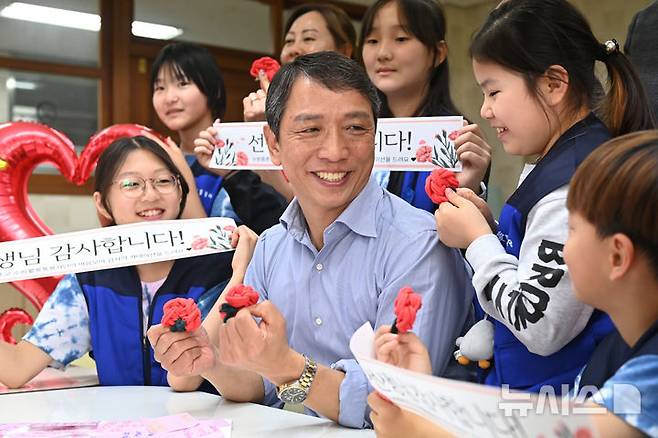 [수원=뉴시스] 김종택 기자 = 스승의 날을 하루 앞둔 14일 경기 수원시 권선구 중촌초등학교에서 통통봉사단 학생들이 직접 만든 카네이션과 감사의 편지를 선생님에게 전달하고 있다. 2025.05.14. jtk@newsis.com