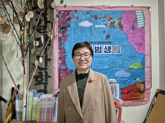 윤선희(59) 신갈야간학교 교감이 신갈야학 현판 앞에서 활짝 웃고 있다. 송현주 기자