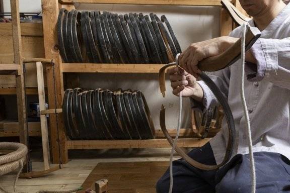 해궁(활시위를 걸어서 활의 균형을 맞추는 작업)을 위해 활에 도지개를 감고 있다.&nbsp; &nbsp;