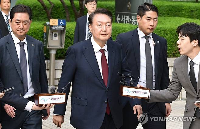 윤석열 전 대통령 '묵묵부답' 사진은 지난 12일 서울 서초구 중앙지방법원에서 열린 내란 우두머리 혐의, 직권남용 권리행사방해 혐의 사건 3차 공판을 마친 뒤 법정을 나서고 있는 윤석열 전 대통령의 모습. [연합뉴스 자료사진]