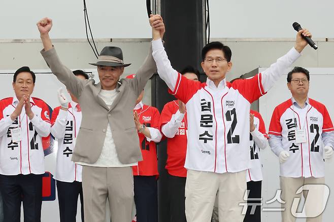 김문수 국민의힘 대통령 후보가 16일 오전 경기도 수원시 팔달구 지동시장에서 가진 유세에서 지난 2020년 서해상에서 북한군에 의해 피살된 공무원의 유족인 이래진 씨와 함께 손을 들어보이며 유권자들에게 인사하고 있다. 2025.5.16/뉴스1 ⓒ News1 이광호 기자