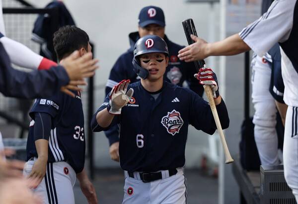 더그아웃에 들어와 축하받는 오명진. ⓒ두산 베어스