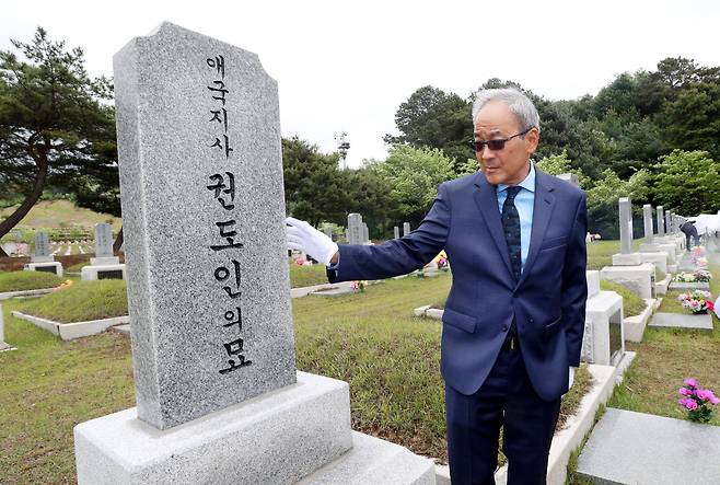 15일 대전 현충원에서 열린 애국지사 권도인 선생의 추모식에 참석한 외손자 폴 아리나가(Paul Arinaga)씨가 할아버지 비석을 쓰다듬고 있다. 이날 특허청은 ‘제1호 미국 특허출원 한국인’이라고 새긴 새로운 비문을 공개했다./신현종 기자