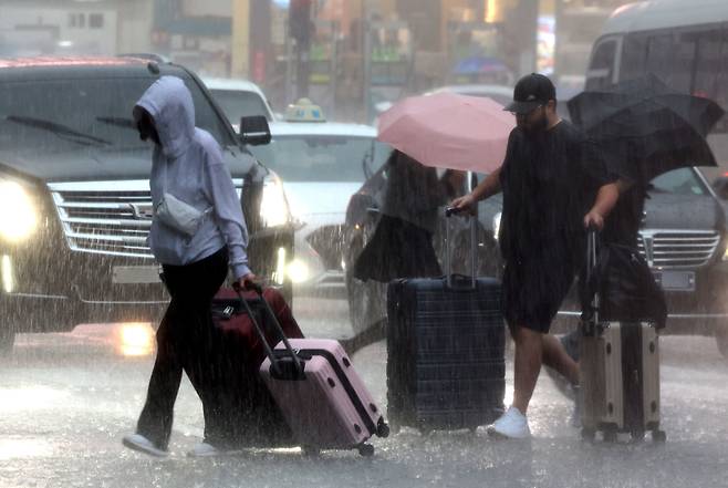 폭우가 쏟아진 16일 오후 서울 중구 퇴계로에서 관광객들이 한치 앞이 보이지 않는 빗속을 뚫고 걸어가고 있다. /뉴시스
