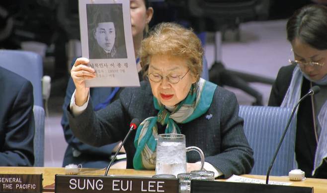 이성의 6·25전쟁납북인사가족협의회 이사장이 15일 미국 뉴욕 유엔본부 안전보장이사회 회의에서 75년 전 납북된 부친의 사진을 들어 보이고 있다. 이 이사장은 “납북자 가족의 마음속 상처는 지금도 아물지 않았다”고 했다./유엔