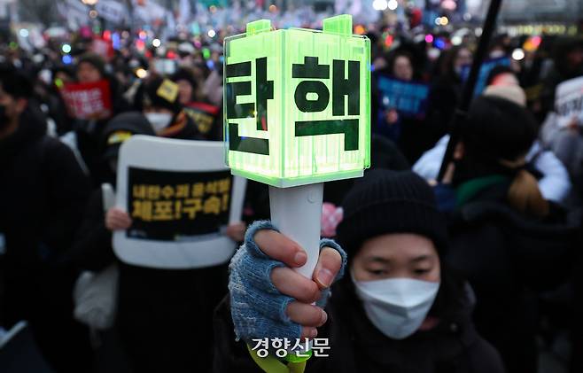 지난해 12월21일서울 종로구 광화문 동십자각 앞에서 열린 윤석열 즉각 체포·퇴진! 사회대개혁! 범시민 대행진 집회에 참석한 시민들이 응원봉을 들고 행진하고 있다. 성동훈 기자