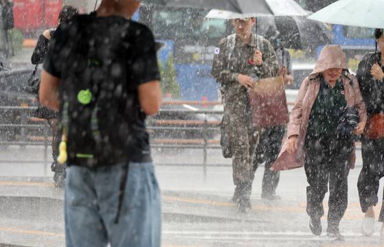 People walk in the rain near Seoul Station in central Seoul on May 16. [YONHAP]