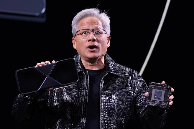 (라스베이거스(미국)=뉴스1) 신웅수 기자 = 젠슨 황 엔비디아 최고경영자(CEO)가 세계 최대 IT(정보기술)·가전 전시회 'CES 2025' 개막을 하루 앞둔 6일(현지시간) 미국 네바다주 라스베이거스 만달레이베이 컨벤션센터에서 가진 기조연설에서 최신 인공지능(AI) 가속기 '블랙웰(Blackwell)'을 탑재한 지포스 RTX 50 시리즈 그래픽 카드를 공개하고 있다. 2025.1.6