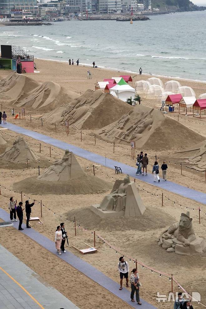 [부산=뉴시스] 하경민 기자 = 15일 부산 해운대구 해운대해수욕장을 찾은 시민과 관광객들이 다양한 모래조각 작품을 구경하고 있다. 해운대구는 오는 16~19일 '2025년 해운대 모래축제'를 개최한다. 올해 20주년을 맞은 모래축제는 '모래로 만나는 K-컬처'를 주제로 14명의 해외 모래 작가가 제작한 총 20여 개의 작품을 선보인다. 모래작품들은 축제 기간 이후인 오는 6월8일까지 전시될 예정이다. 2025.05.15. yulnetphoto@newsis.com