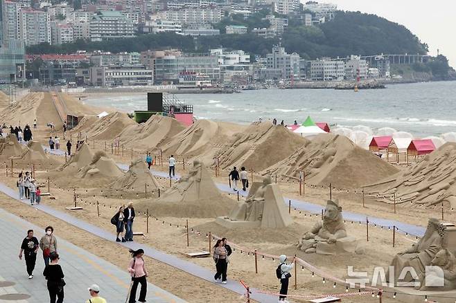 [부산=뉴시스] 하경민 기자 = 15일 부산 해운대구 해운대해수욕장을 찾은 시민과 관광객들이 다양한 모래조각 작품을 구경하고 있다. 해운대구는 오는 16~19일 '2025년 해운대 모래축제'를 개최한다. 올해 20주년을 맞은 모래축제는 '모래로 만나는 K-컬처'를 주제로 14명의 해외 모래 작가가 제작한 총 20여 개의 작품을 선보인다. 모래작품들은 축제 기간 이후인 오는 6월8일까지 전시될 예정이다. 2025.05.15. yulnetphoto@newsis.com